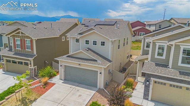 craftsman house with a mountain view, a garage, and solar panels