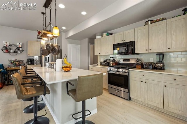 kitchen featuring a kitchen island, light hardwood / wood-style flooring, tasteful backsplash, and stainless steel range with gas stovetop