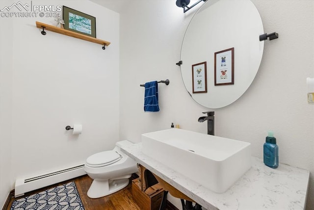 bathroom featuring a baseboard radiator, wood-type flooring, sink, and toilet