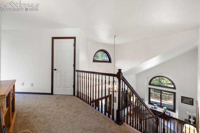 hallway with vaulted ceiling and carpet