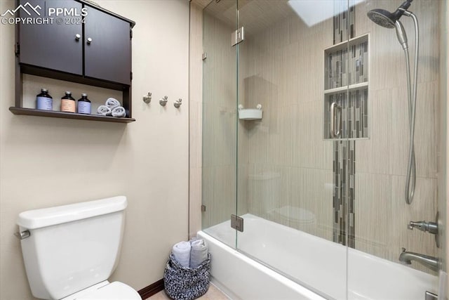 bathroom featuring toilet and bath / shower combo with glass door