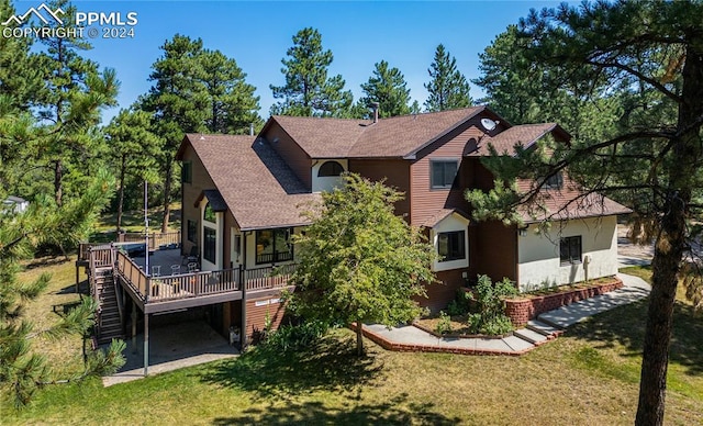 rear view of house featuring a wooden deck and a yard