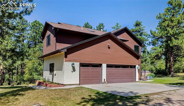 view of side of property featuring a garage and a yard