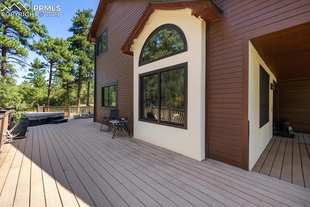 wooden deck with a covered hot tub