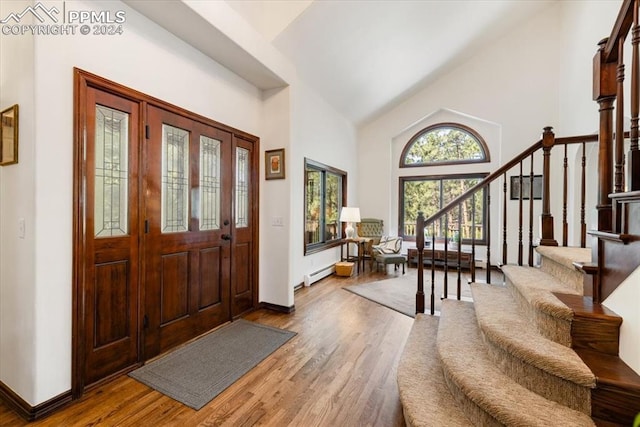 foyer featuring high vaulted ceiling, hardwood / wood-style floors, and baseboard heating