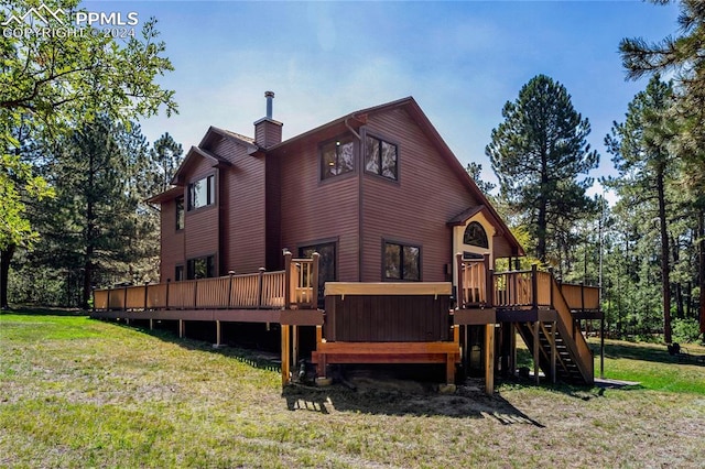 back of house featuring a wooden deck and a lawn