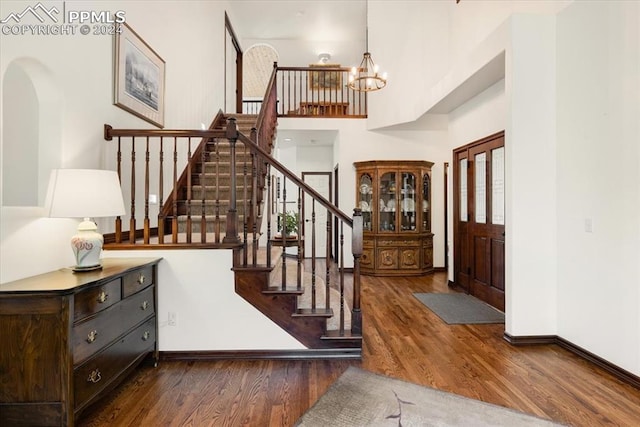 foyer entrance with a notable chandelier and dark hardwood / wood-style flooring