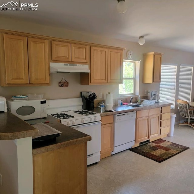 kitchen with light brown cabinetry, sink, white appliances, and light tile patterned floors