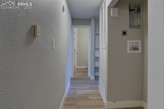 corridor featuring built in shelves and light wood-type flooring