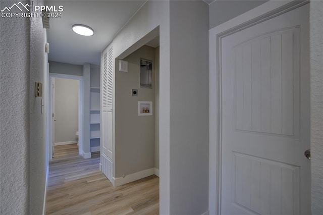 corridor featuring light hardwood / wood-style flooring and built in features