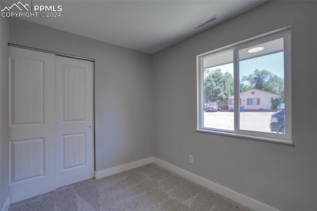 unfurnished bedroom with carpet flooring and a closet