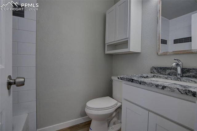 bathroom with vanity, hardwood / wood-style flooring, and toilet