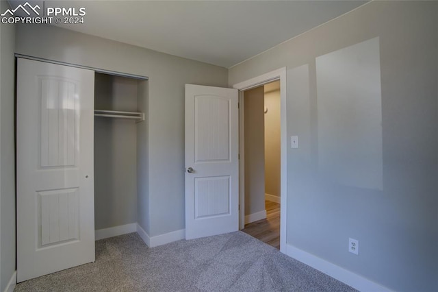 unfurnished bedroom with a closet and carpet flooring