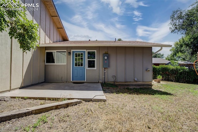 entrance to property featuring a yard and a patio area