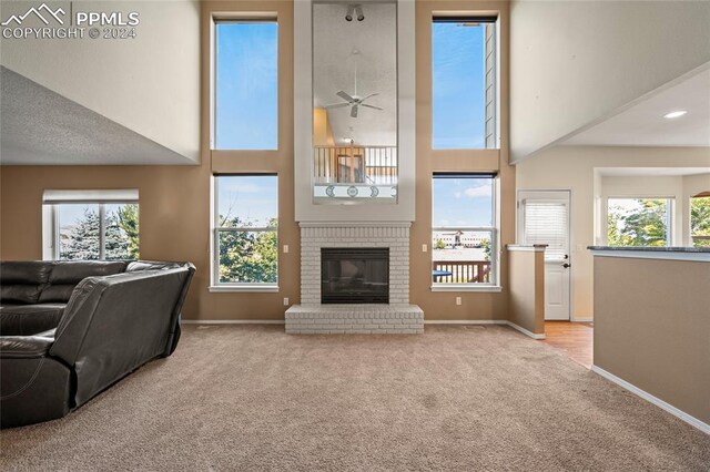 living room featuring light colored carpet, a fireplace, and plenty of natural light