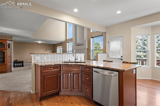 kitchen featuring sink, dishwasher, light colored carpet, and plenty of natural light