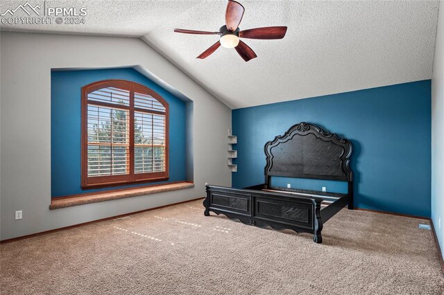 carpeted bedroom featuring ceiling fan, vaulted ceiling, and a textured ceiling