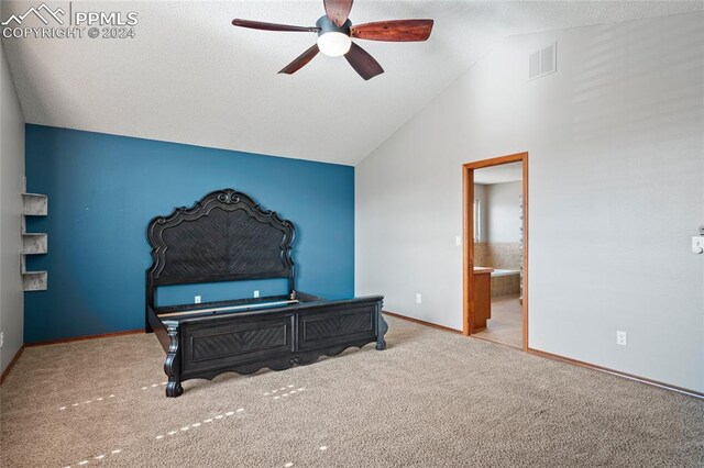 bedroom with a textured ceiling, lofted ceiling, ceiling fan, connected bathroom, and light carpet