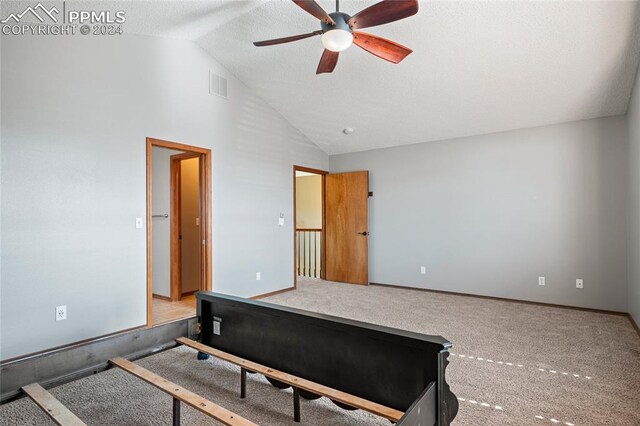 carpeted bedroom with ceiling fan, high vaulted ceiling, and a textured ceiling