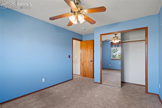 unfurnished bedroom with a textured ceiling, carpet floors, ceiling fan, and a closet