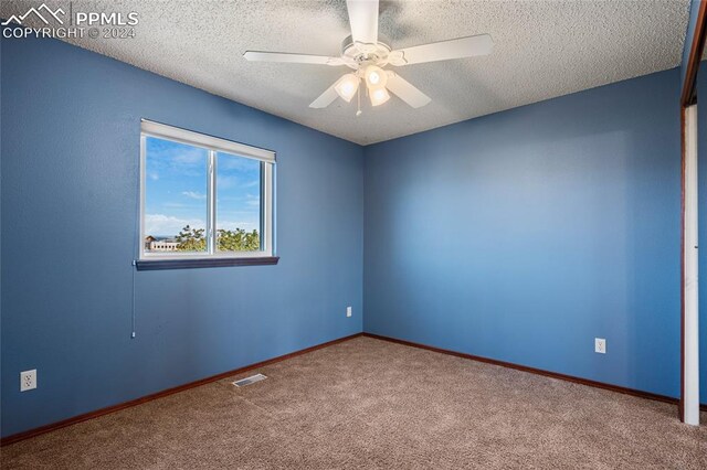 unfurnished room featuring a textured ceiling, carpet floors, and ceiling fan