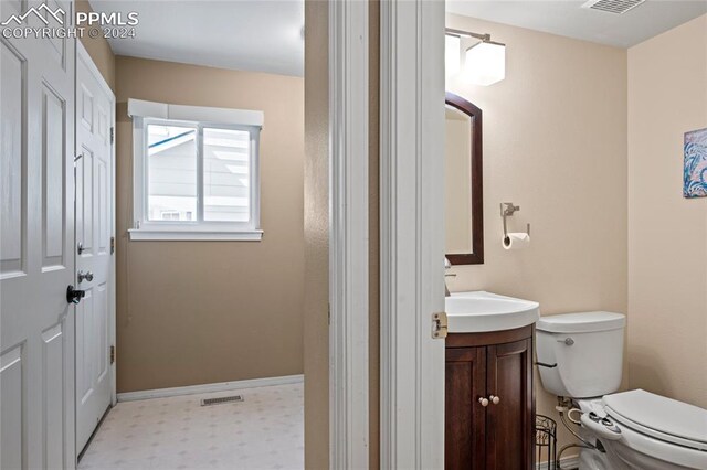 bathroom featuring tile patterned flooring, toilet, and vanity