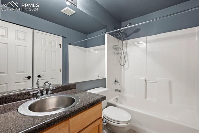 full bathroom featuring shower / bathtub combination, vanity, and toilet