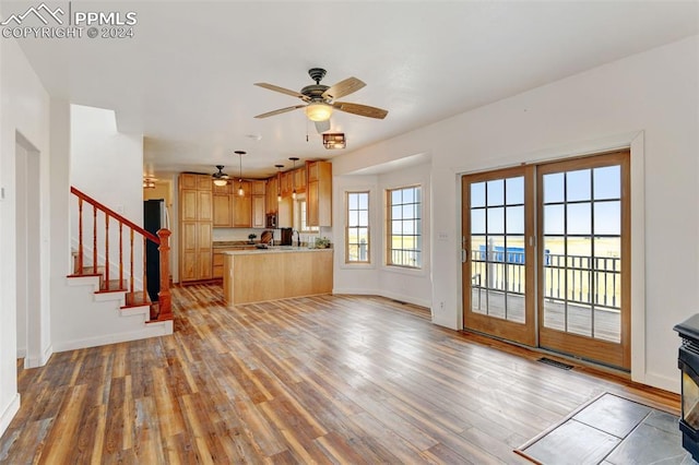 unfurnished living room featuring light hardwood / wood-style flooring and ceiling fan