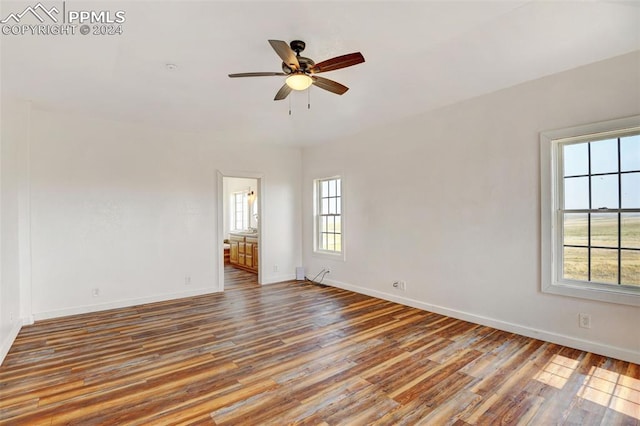 unfurnished room with wood finished floors, baseboards, and a ceiling fan
