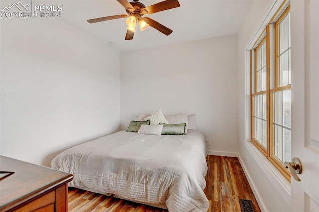 bedroom featuring multiple windows, hardwood / wood-style floors, and ceiling fan