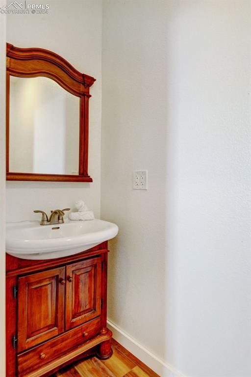 bathroom featuring baseboards, vanity, and wood finished floors