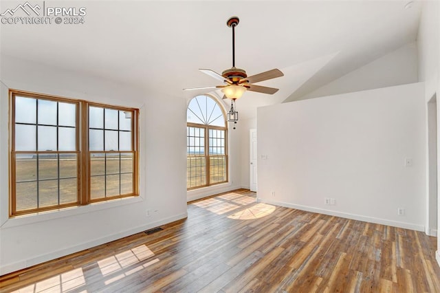 empty room featuring hardwood / wood-style flooring, vaulted ceiling, and ceiling fan