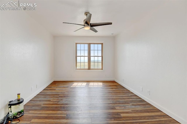 spare room featuring wood finished floors, baseboards, and a ceiling fan