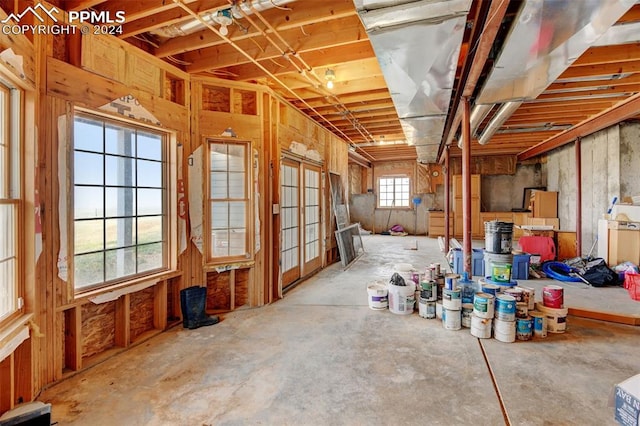 miscellaneous room featuring baseboard heating and unfinished concrete floors