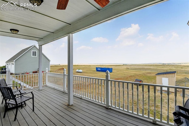 deck featuring a storage shed and a rural view