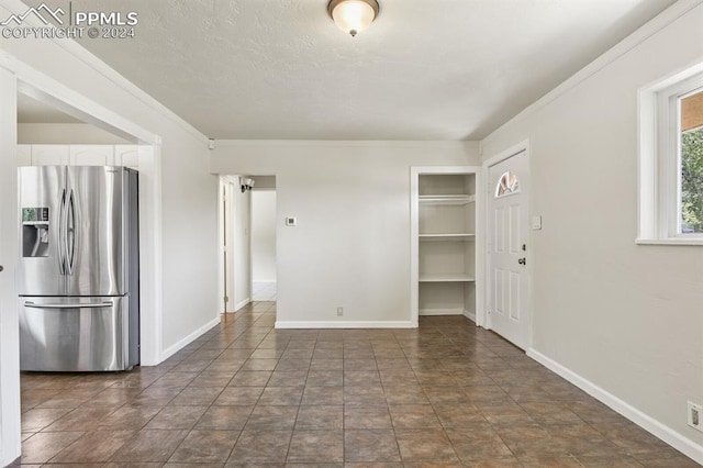 interior space with white cabinetry, dark tile patterned floors, and stainless steel refrigerator with ice dispenser