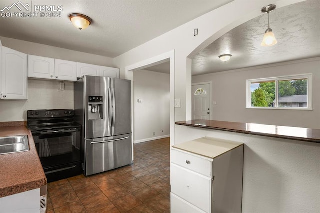 kitchen featuring dark tile patterned flooring, sink, white cabinets, stainless steel fridge, and black range with electric cooktop