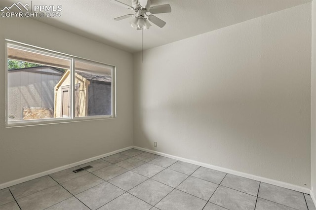 empty room featuring ceiling fan and light tile patterned floors