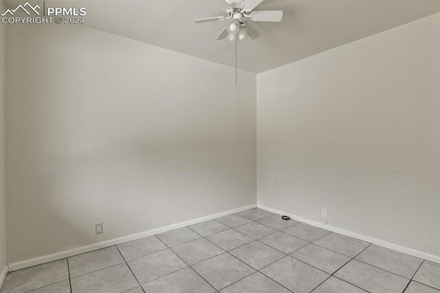 tiled spare room featuring ceiling fan