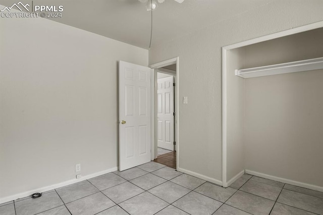 unfurnished bedroom featuring a closet, ceiling fan, and light tile patterned floors