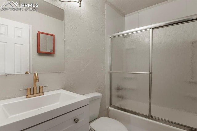 full bathroom featuring shower / bath combination with glass door, toilet, and vanity