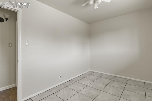 empty room with ceiling fan and light tile patterned flooring