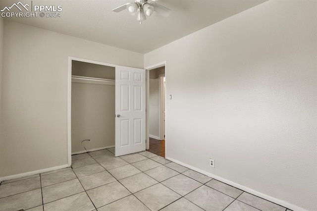 unfurnished bedroom featuring ceiling fan, light tile patterned floors, and a closet