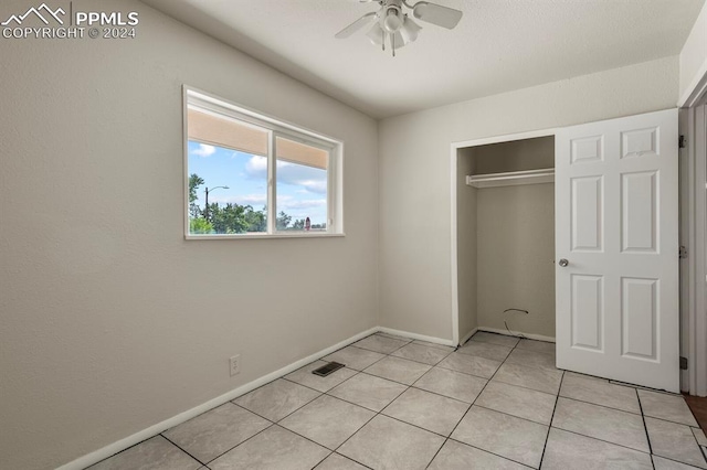 unfurnished bedroom featuring ceiling fan, light tile patterned floors, and a closet