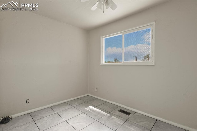 tiled empty room featuring ceiling fan