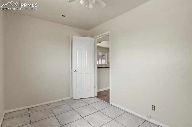 tiled spare room with ceiling fan