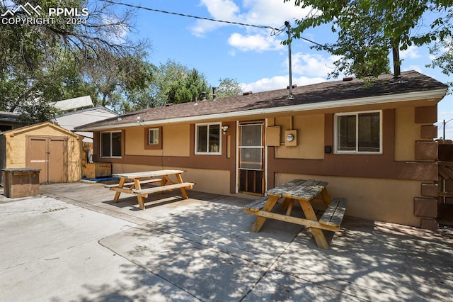 view of front of home with a storage unit and a patio