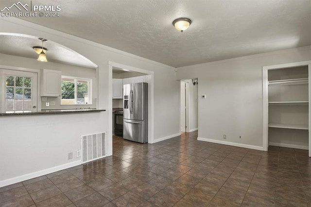 unfurnished living room featuring dark tile patterned floors