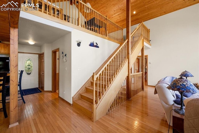 staircase with light hardwood / wood-style flooring and wooden ceiling