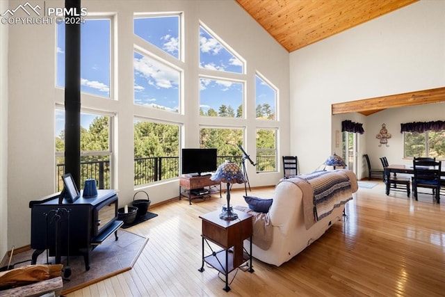 living room featuring wooden ceiling, light wood-type flooring, high vaulted ceiling, and plenty of natural light